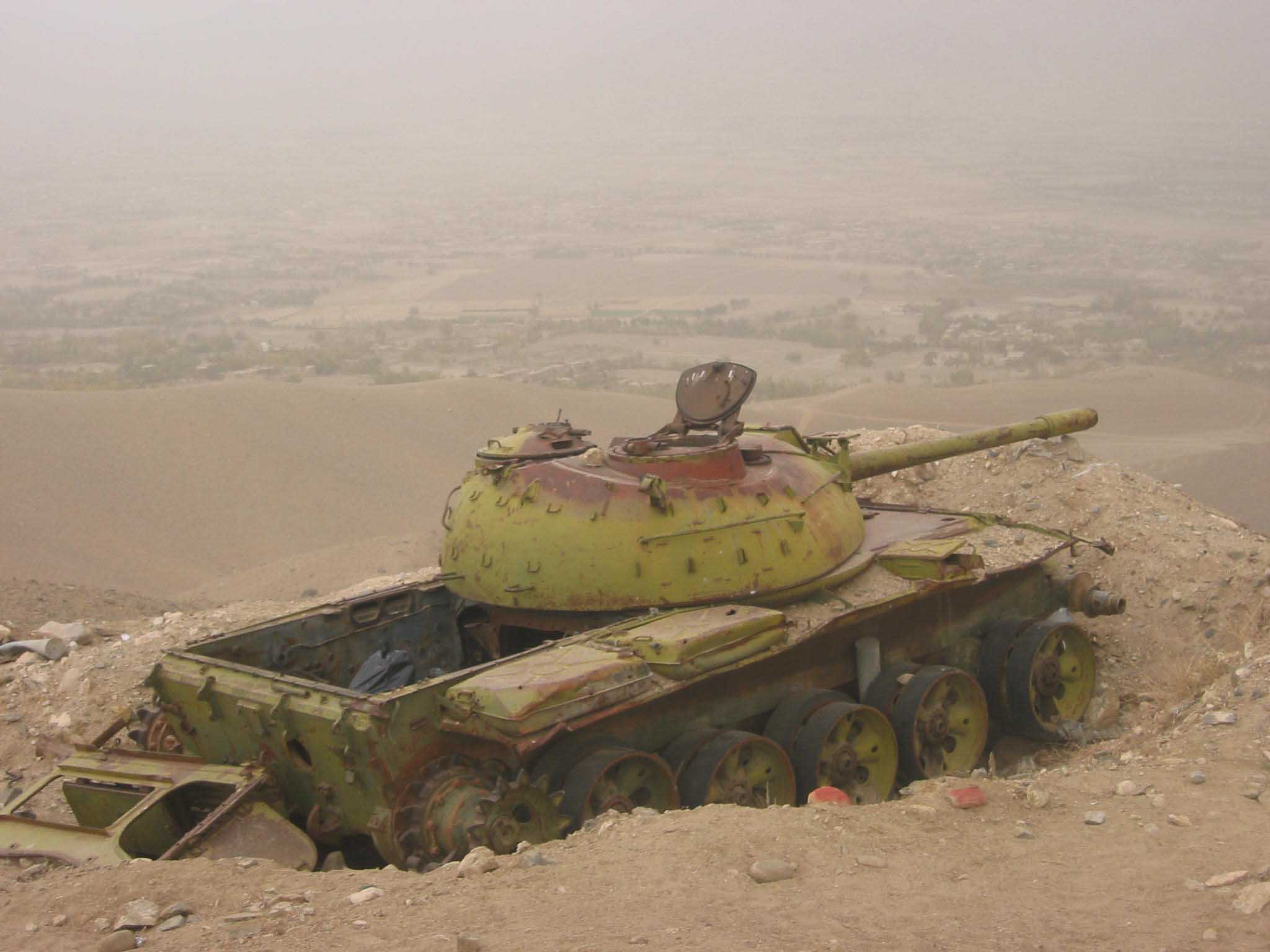 A derelict Soviet tank stands sentinel in a dug-in position in the mountains surrounding  Kabul in Afghanistan. The red rocks mark mines that have still not been cleared.