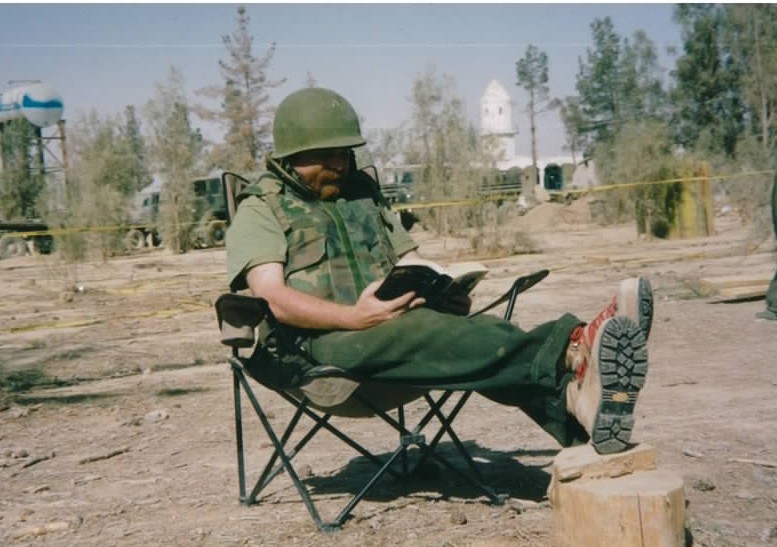 Me, pretending to read Pickwick Papers outside the media tent at Kandahar Airfield. The tin hat and flack jacket weren't exactly up to code but both were the price of admission for reporters to the base. 